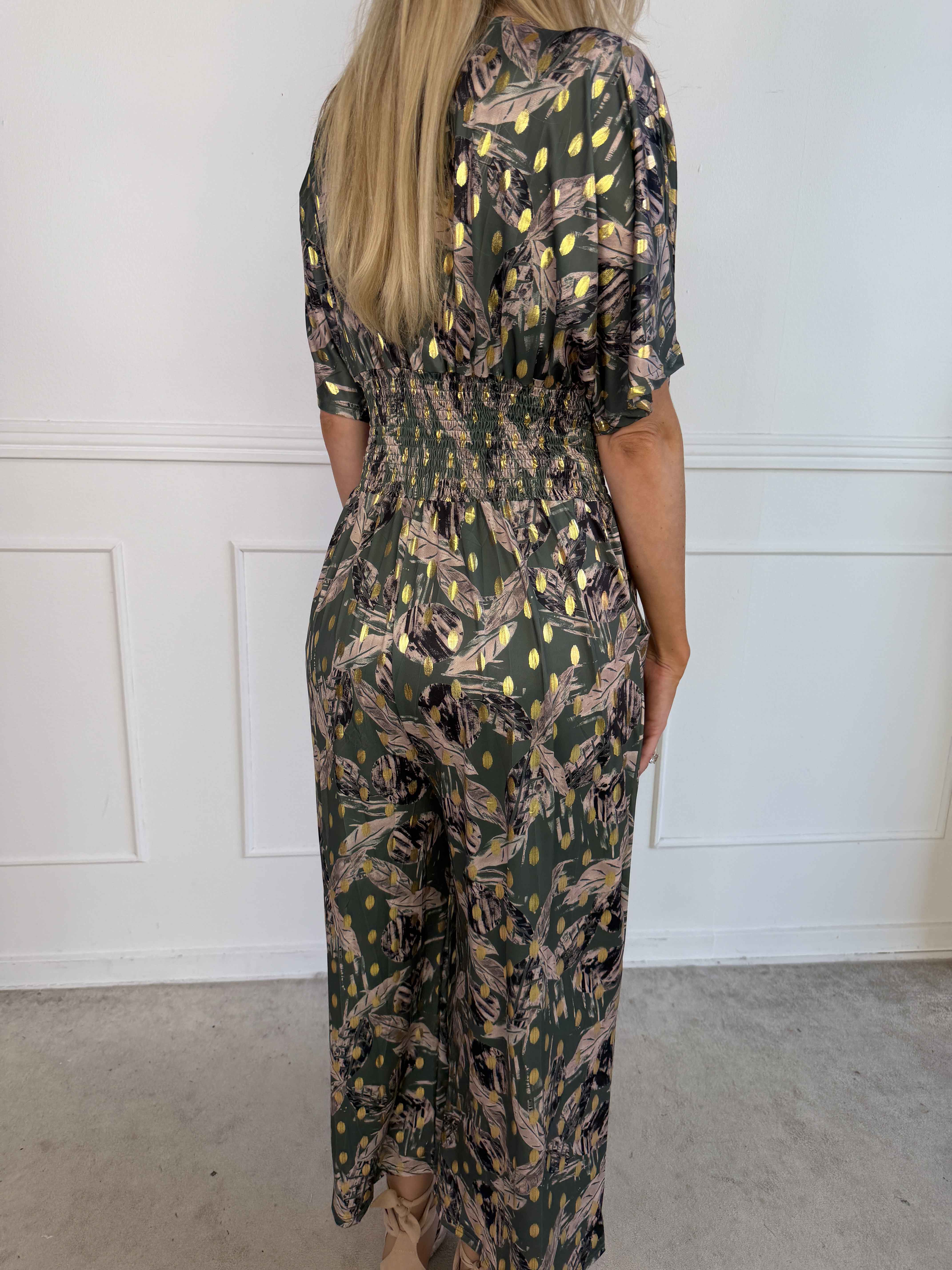 Pams Leafage Jumpsuit - Elastisk jumpsuit i lövmönster med guldfärgade tofsar